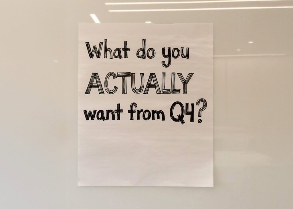 Handwritten text asking "What do you actually want from Q4?" on beige paper with soft lighting