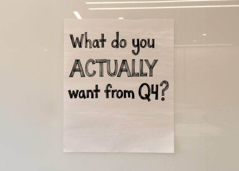 Handwritten text asking "What do you actually want from Q4?" on beige paper with soft lighting